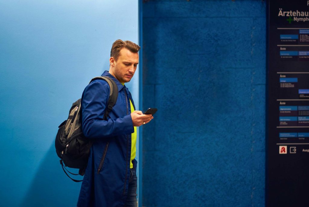 Junger Mann vor blauer Tür