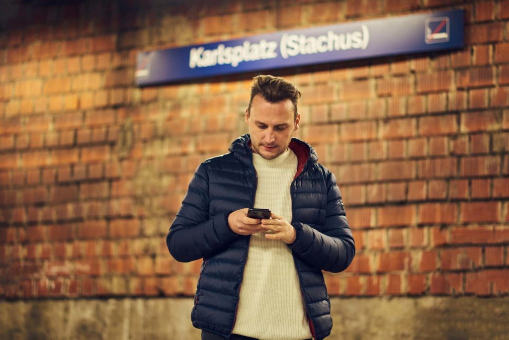 Junger Mann bucht einen Termin aus der U-Bahn in der Smartpraxis