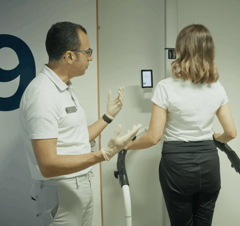 Dr. Sirfy führt eine Patientin beratend durch die Bioimpedanzanalyse in der SmartPraxis München